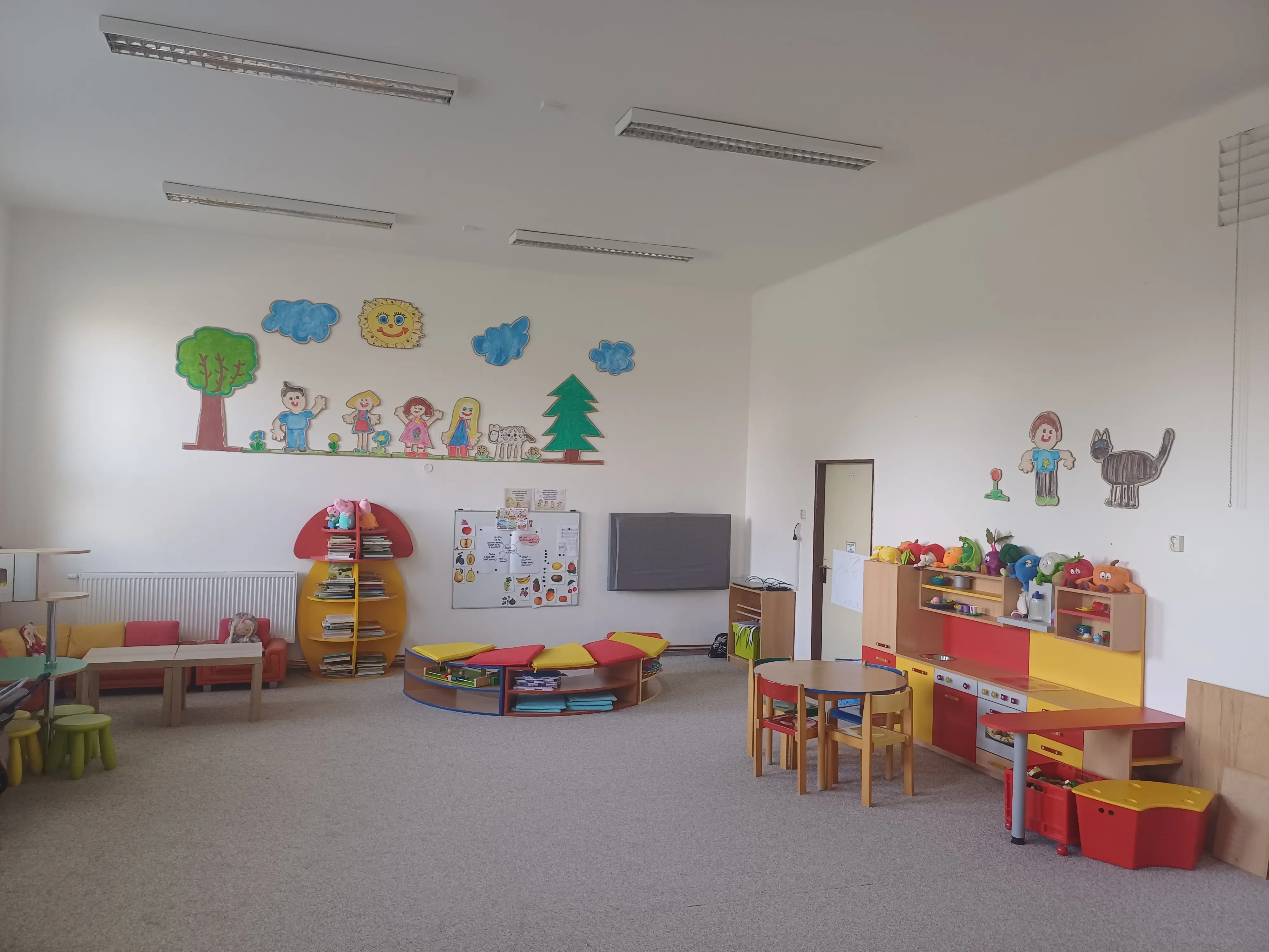 Pohled na zadní část třídy, kde je velký prostor s kobercem vhodný pro hru a učení